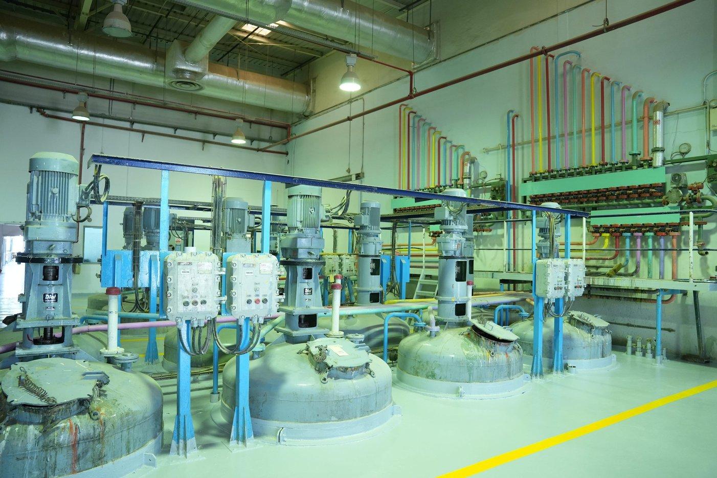 Industrial production line with green cylindrical tanks