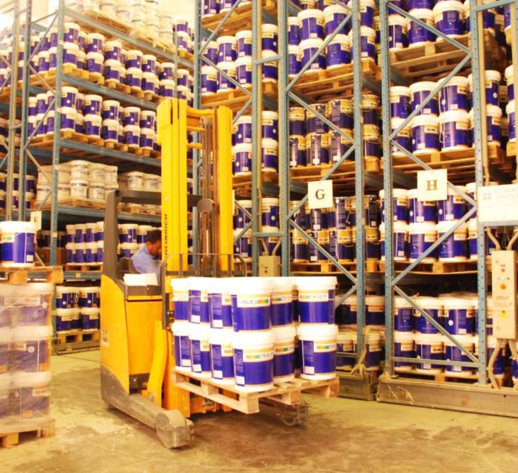 Warehouse storage with stacked paint containers and forklift